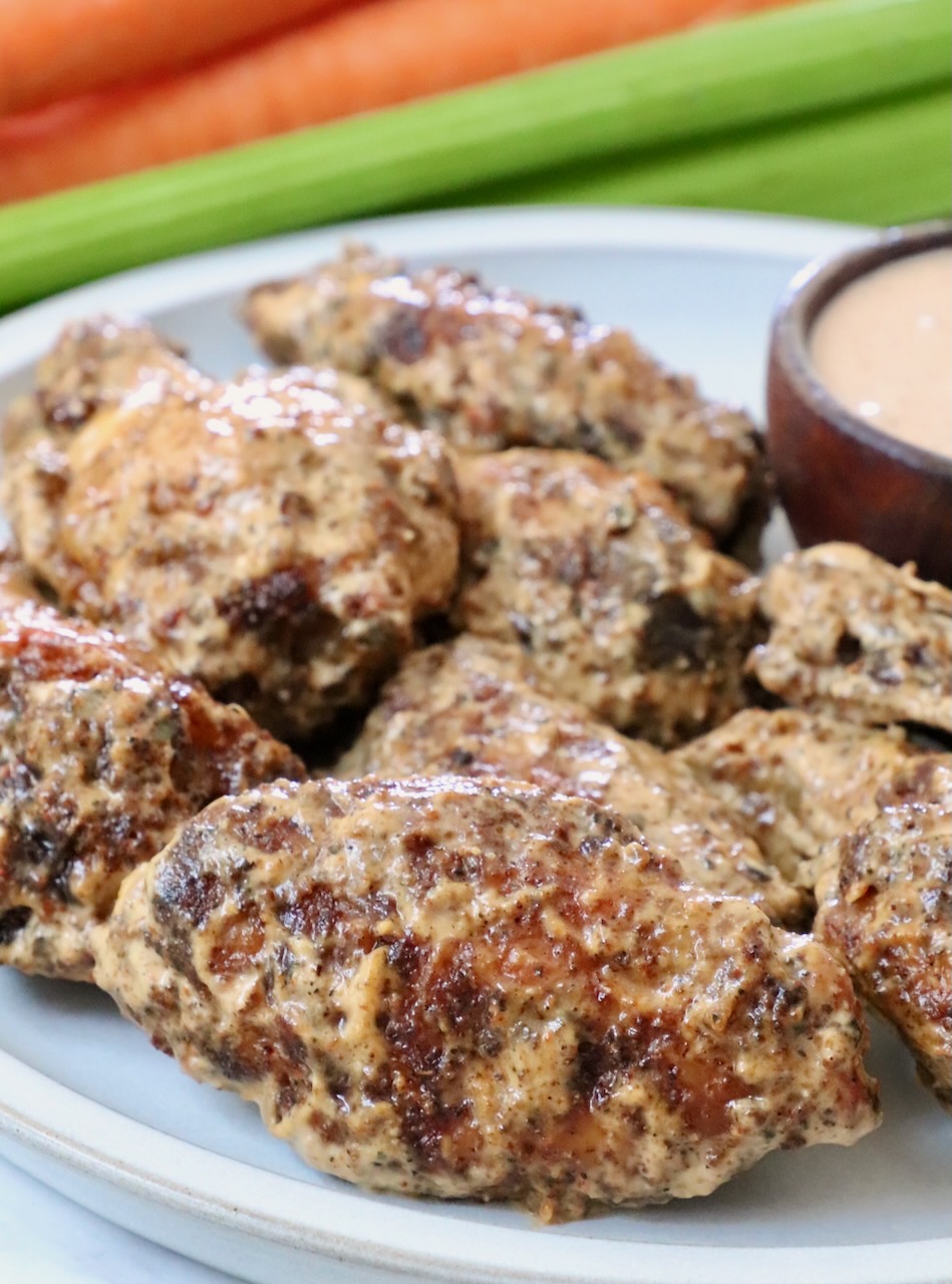 cooked chicken wings tossed in a creamy sauce on a plate