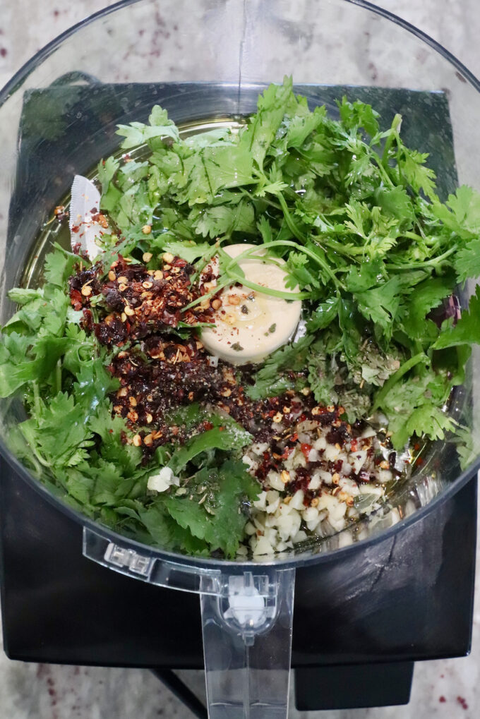 fresh cilantro with spices and garlic in a food processor