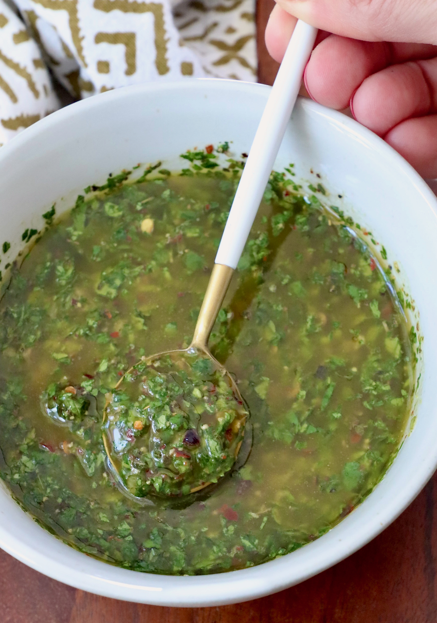 cilantro chimichurri sauce in a bowl with a small spoon