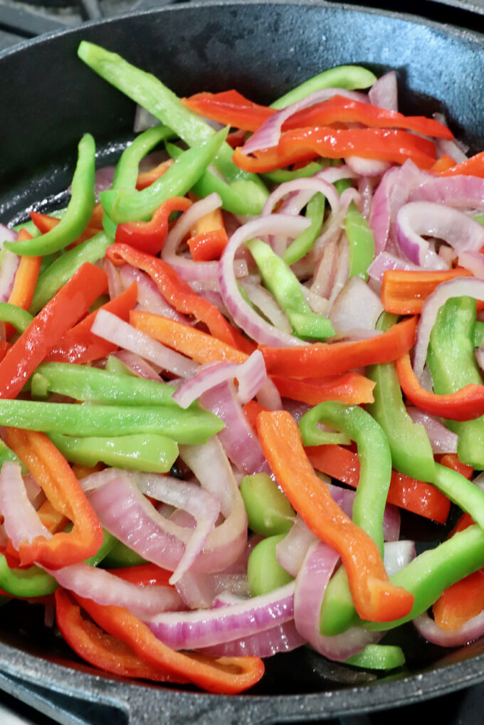 sliced bell peppers and onions in a skillet