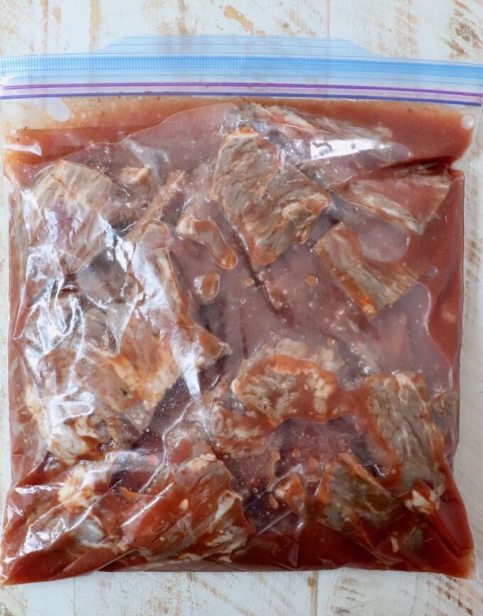 steak tips marinating in a large plastic zipper bag