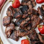 grilled steak bites on a plate with cherry peppers