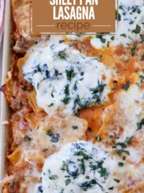 A close-up of a baked sheet pan lasagna with butternut squash. Topped with melty cheese and spinach, garnished with herbs. Text overlay: "Butternut Squash Sheet Pan Lasagna Recipe."