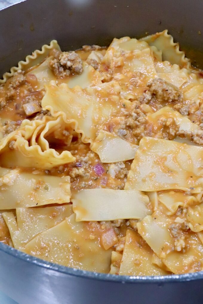 cooked, broken lasagna noodles tossed with a butternut squash meat sauce in a pot