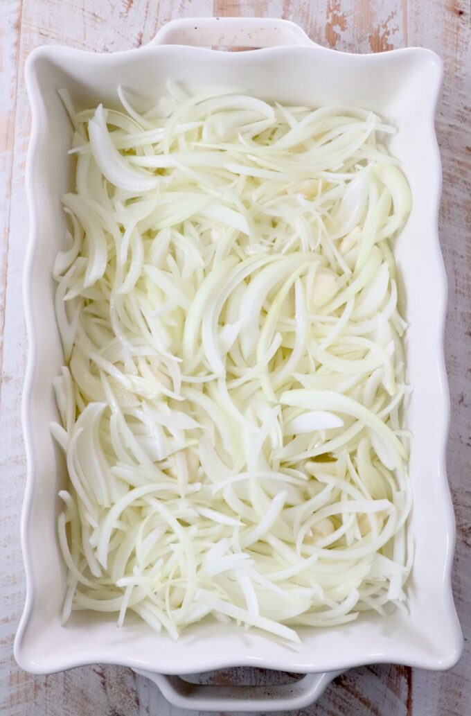sliced onions in a white casserole dish