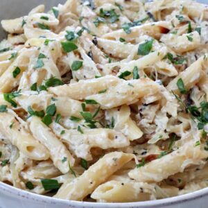 cooked penne pasta in a creamy sauce in a bowl