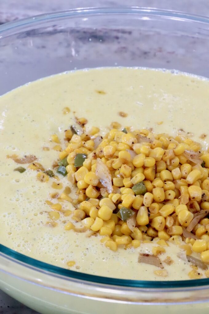 pureed corn soup topped with roasted corn kernels in a large glass bowl