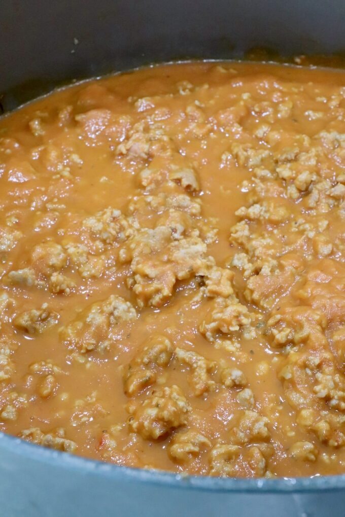 cooked, crumbled sausage in butternut squash sauce in a large pot