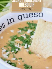 A creamy queso dip topped with cilantro and crumbled cheese in a white bowl with a tortilla chip. Text: "Easy Appetizer, Secret Ingredient Queso Dip Recipe."