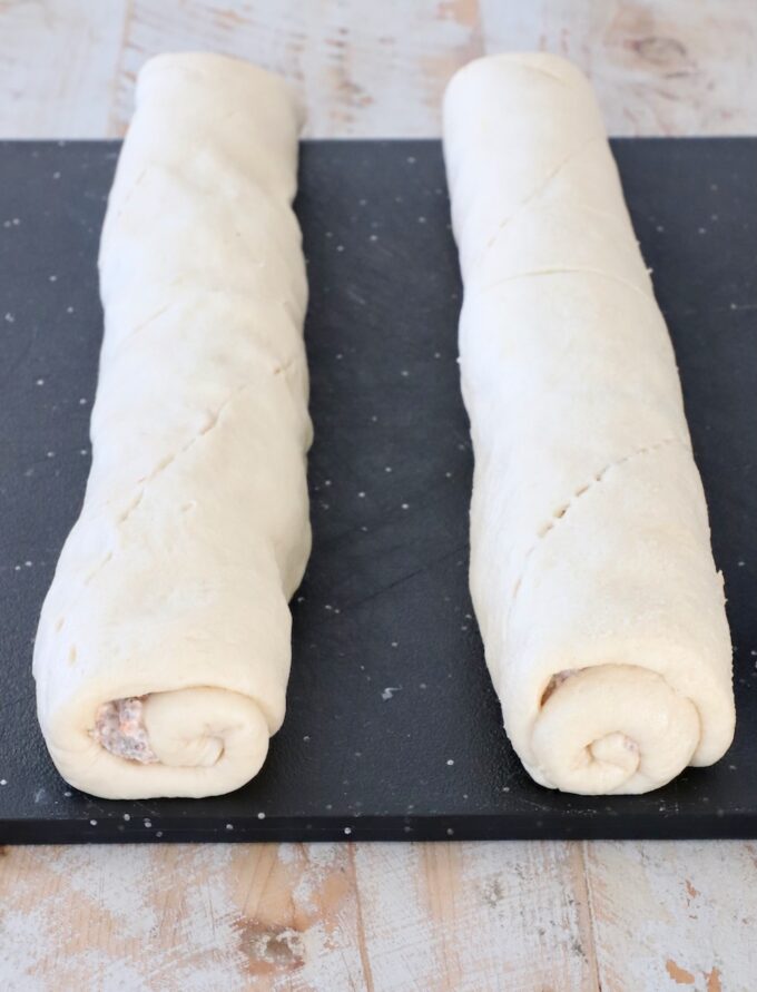 rolled up crescent roll dough on a cutting board