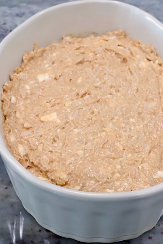 A white ceramic dish filled with unbaked creamy chicken dip