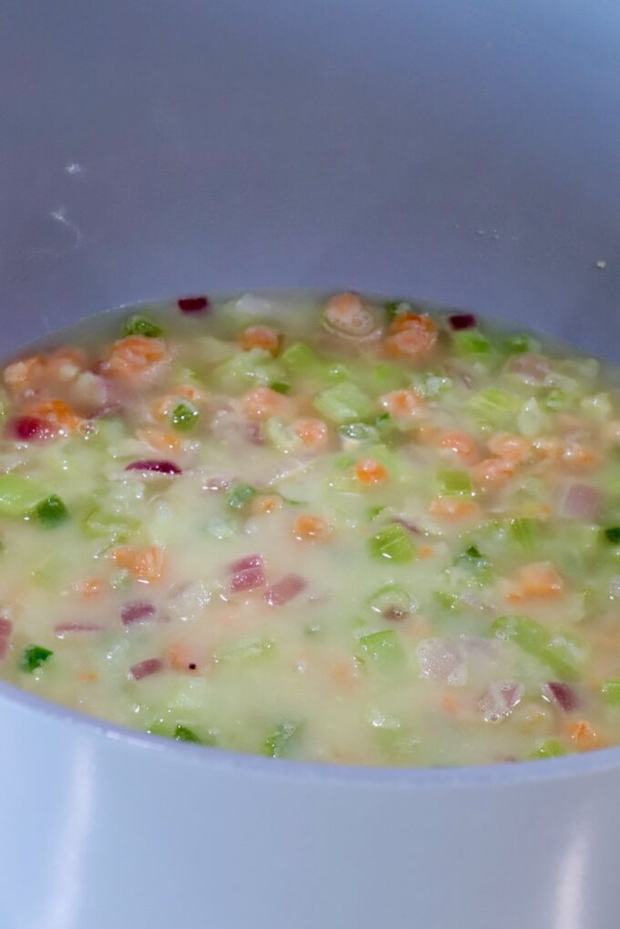 diced vegetables in a roux mixture in a large pot