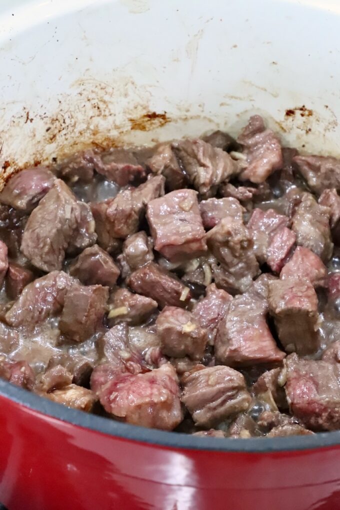 seared pieces of beef in a large pot