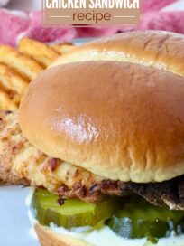 A Chick-fil-A copycat air fryer chicken sandwich on a bun with pickles and sauce, served on a plate beside waffle fries. Text overlay details the recipe.