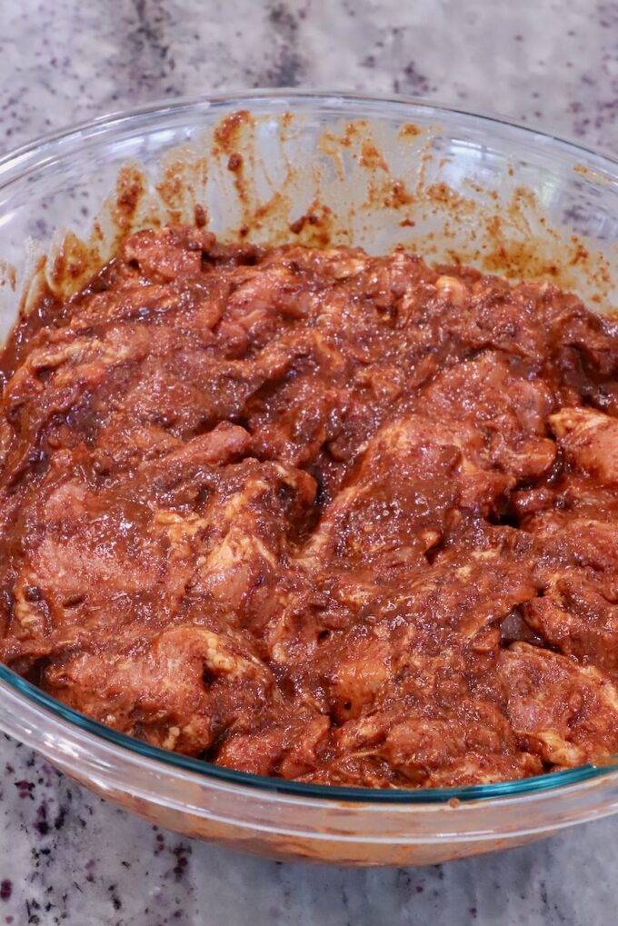 thinly sliced pork tossed in a spicy Mexican marinade in a glass bowl